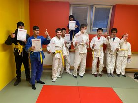 Ein Gruppenbild von Judo-Schülern, die jeweils eine Urkunde in den Händen halten
