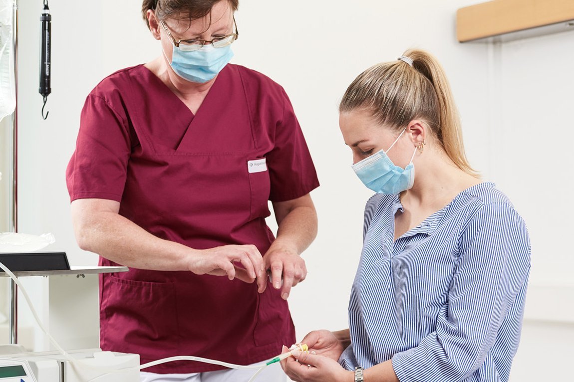 Eine Krankenpflegerin und eine Patientin bei der Bauchfelldialyse