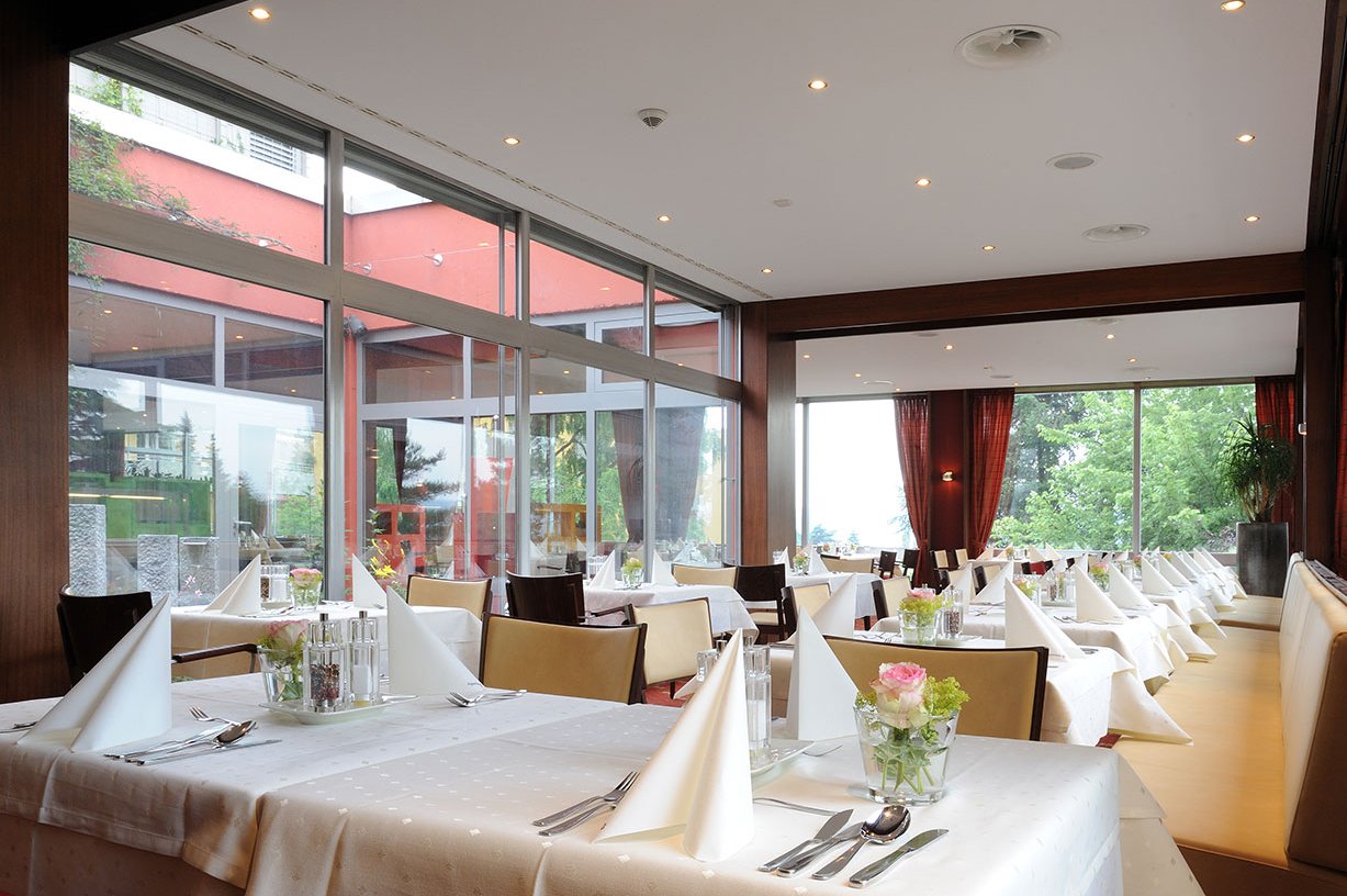An festlich gedeckten Tischen treffen sich die Bewohner*innen im Restaurant zum Essen und zum Austausch von Neuigkeiten. 