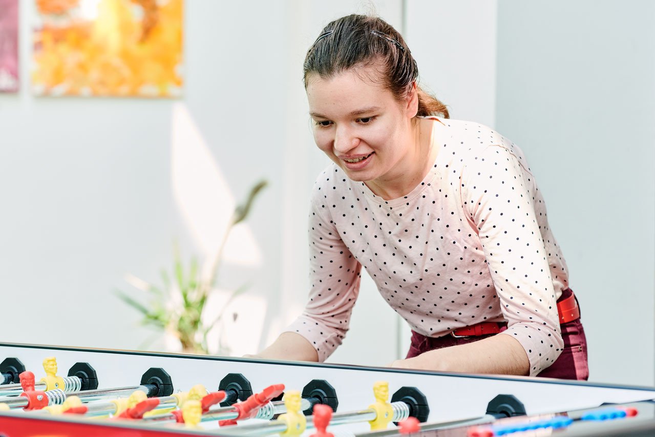 Eine Klient*in spielt Tischfußball