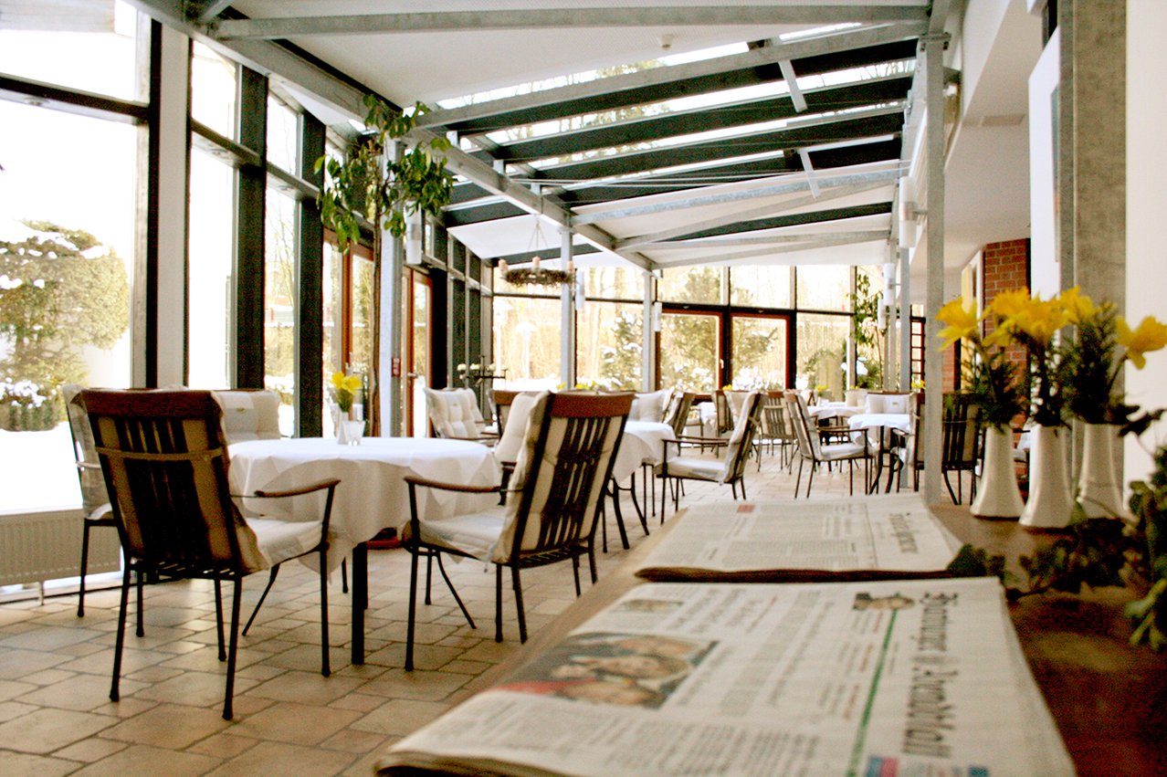 Der lichtdurchflutete Wintergarten lädt ein zu einem ausgiebigen Frühstück mit ausführlicher Zeitungslektüre.