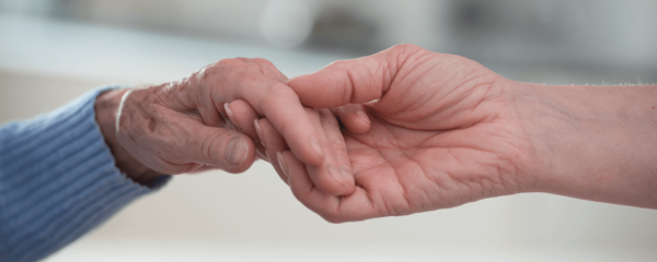 Palliative Care Junge Hand, die alte Hand hält