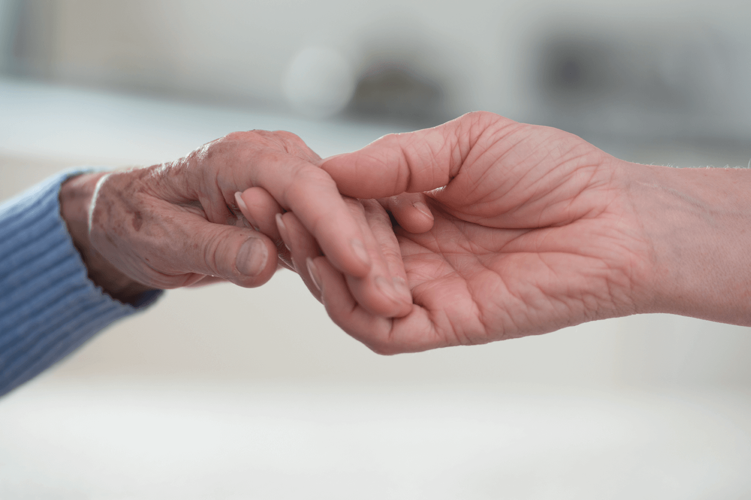 Junge Hand, die alte Hand hält