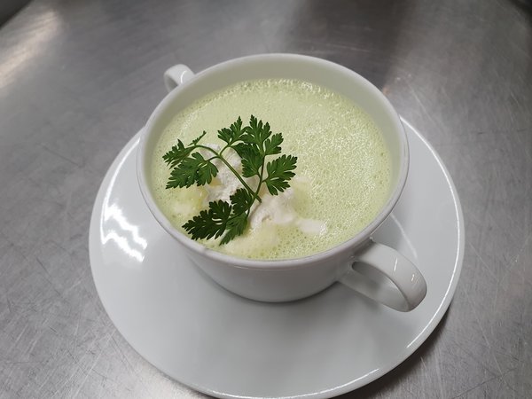Suppentasse mit aufgeschäumter Erbsensuppe
