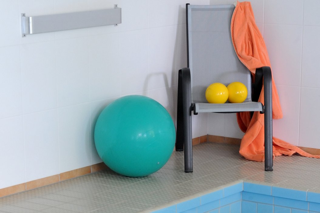 Gymnastikbälle am Rand eines Schwimmbeckens
