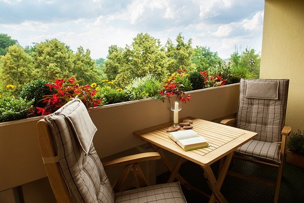 Ein Tisch und zwei Stühle auf der Loggia eines Appartements
