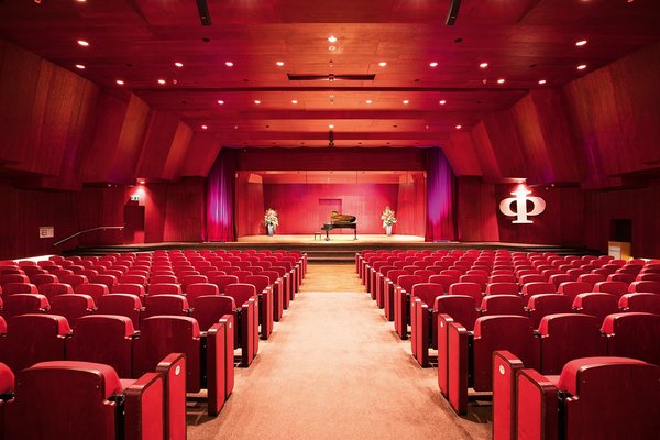 Ein Theatersaal mit einer Bühne und roten Sitzen