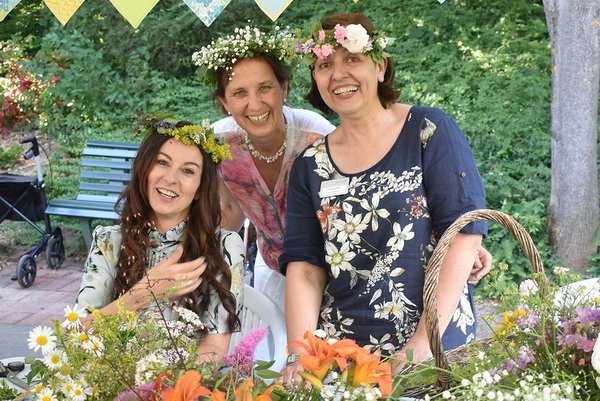 Drei Mitarbeiterinnen des Augustinum mit Blumenkränzen beim Mittsommer-Fest