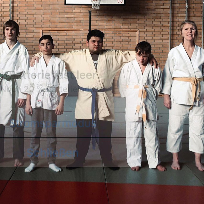 Behinderte Judoka stehen Arm in Arm nebeneinander