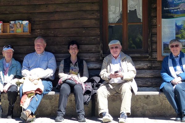 Senior*innen sitzen lächelnd bei einem Ausflug