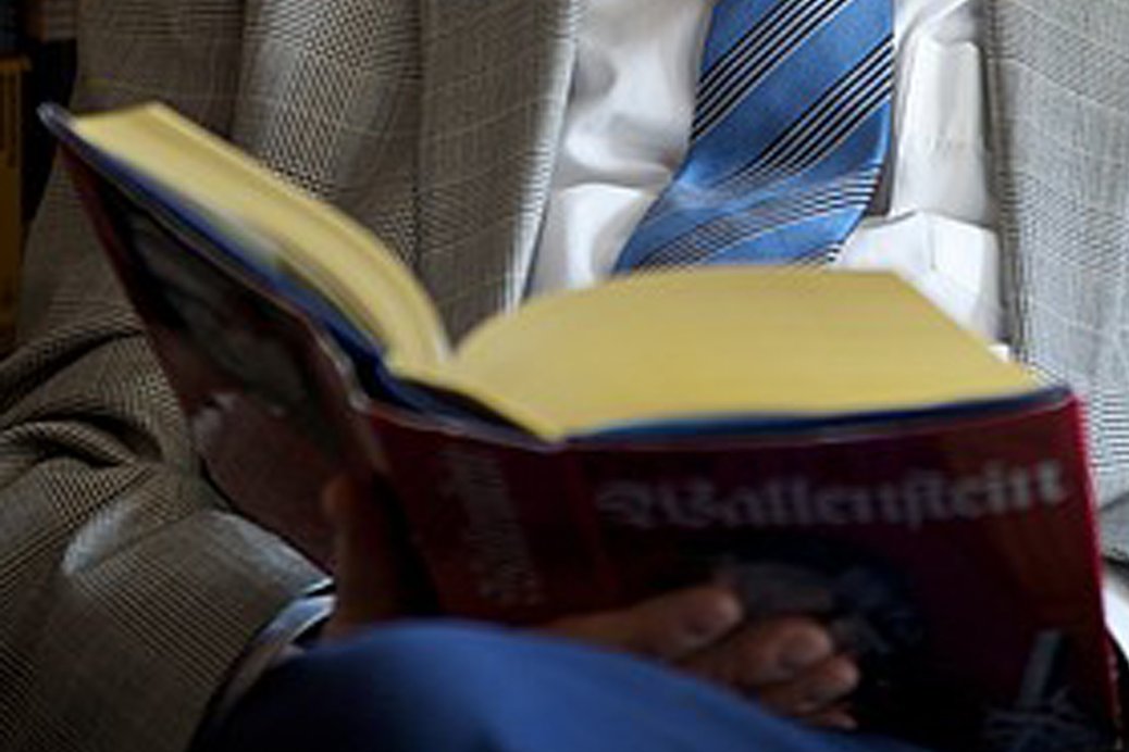 aufgeschlagenes Buch auf dem Schoß eines Mannes