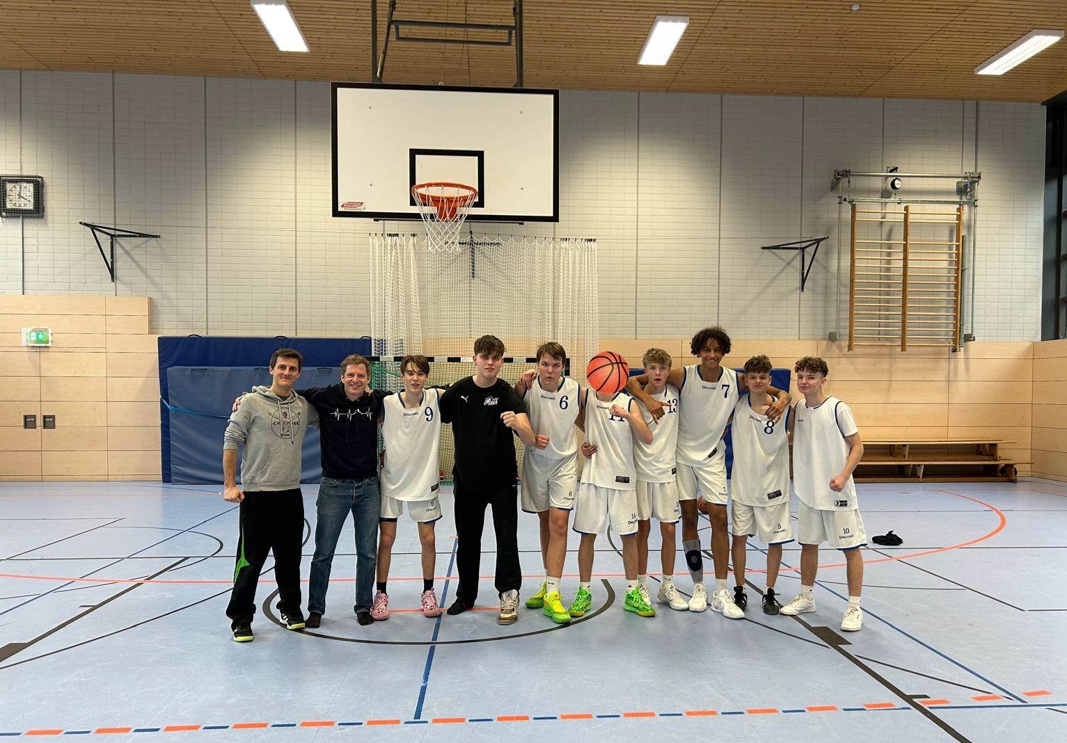 Ein Gruppenfoto der Basketballmannschaft der Samuel Heinicke Realschule in einer Turnhalle