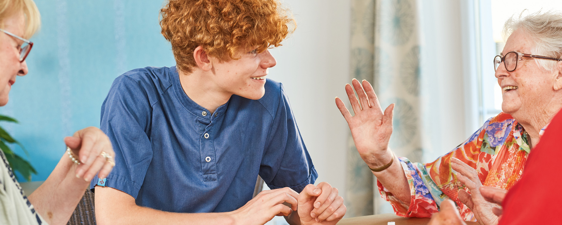 Ein Pfleger des Augustinum unterhält sich mit zwei Seniorinnen