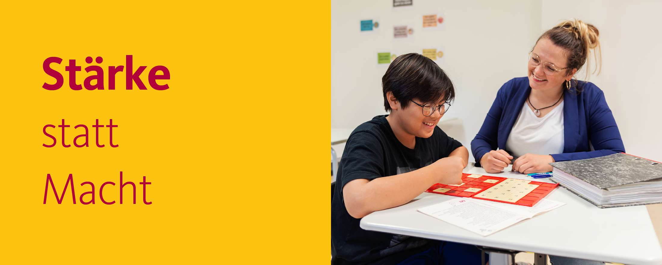 Eine Lehrerin und ein Schüler bearbeiten gemeinsam eine Übung, daneben die Worte "Stärke statt Macht"