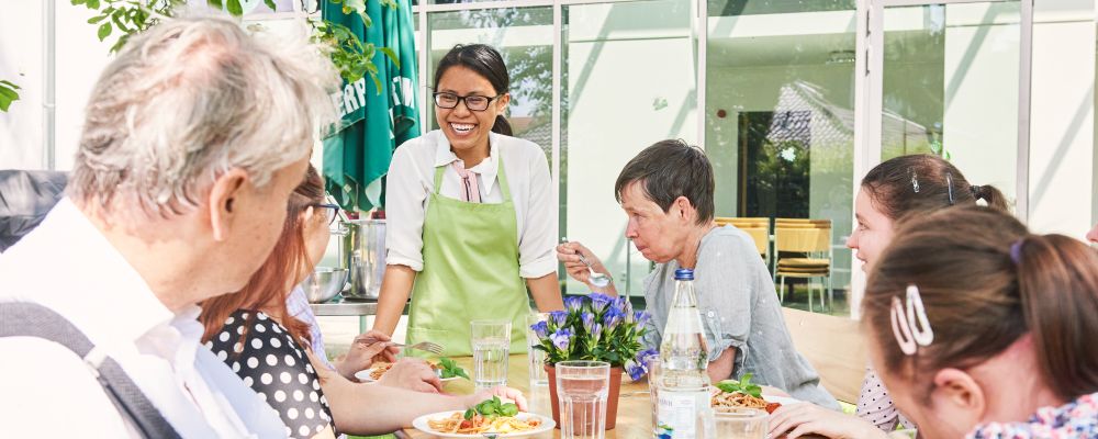 Gruppe im inklusiven Restaurant am Tisch im Außenbereich